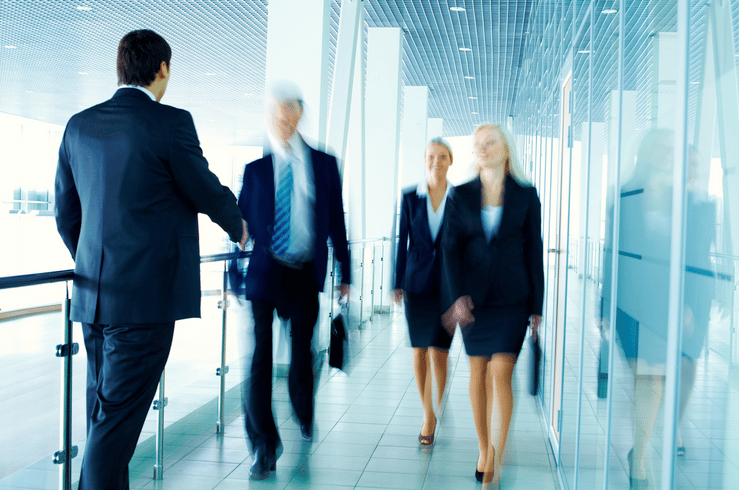 Four personal injury lawyers walk down a hallway.