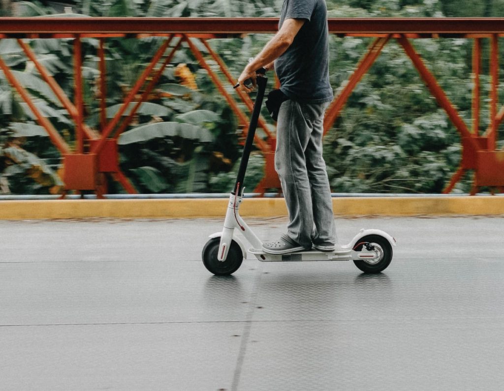 Class Action Lawsuit Against E-Scooter Companies: Image a man riding a scooter.