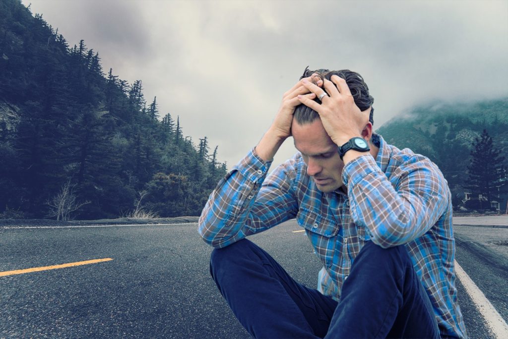 Image of a seated man in mental distress.