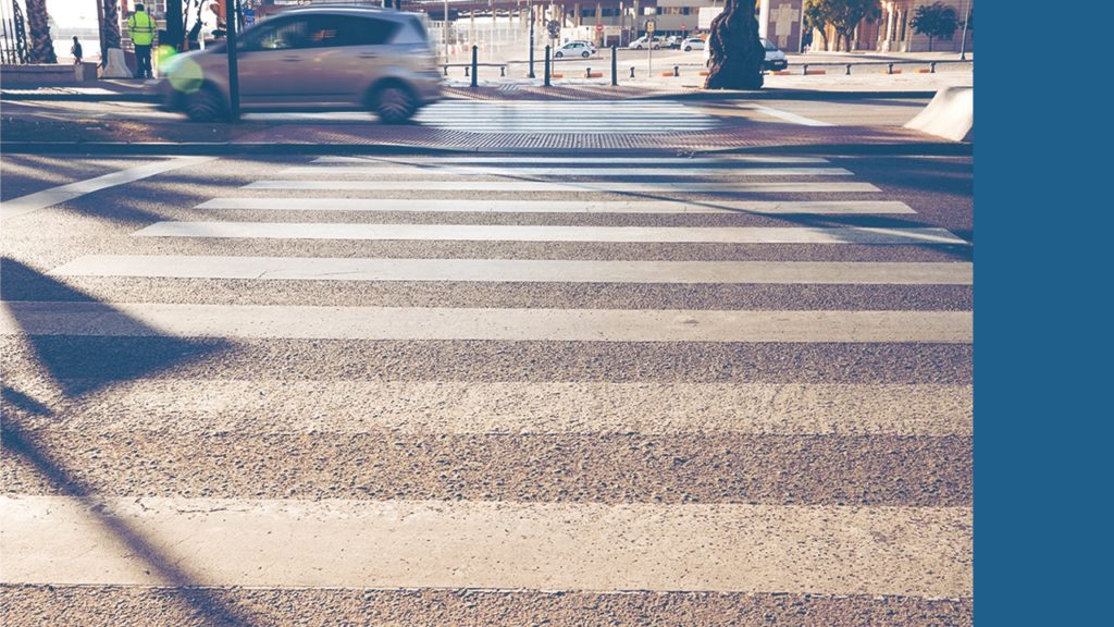 A crosswalk on a busy street that protects pedestrians. Getting stuck by a vehicle in a crosswalk can be grounds for a personal injury claim.