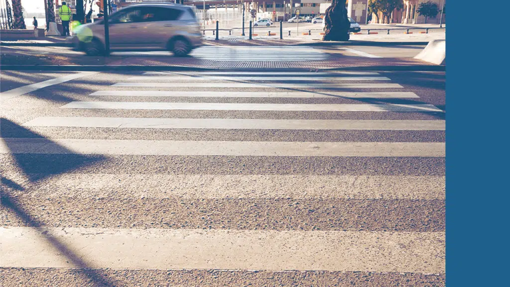 A crosswalk on a busy street that protects pedestrians.