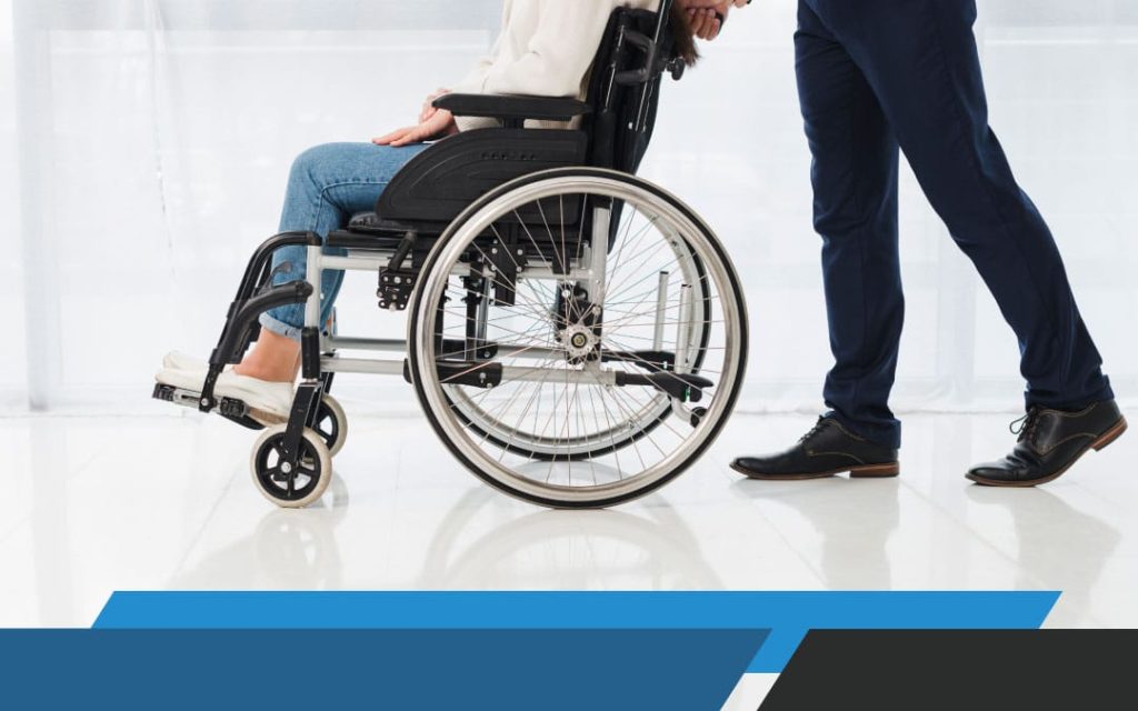 A picture of a personal injury lawyer pushing a wheelchair with an injured plaintiff.
