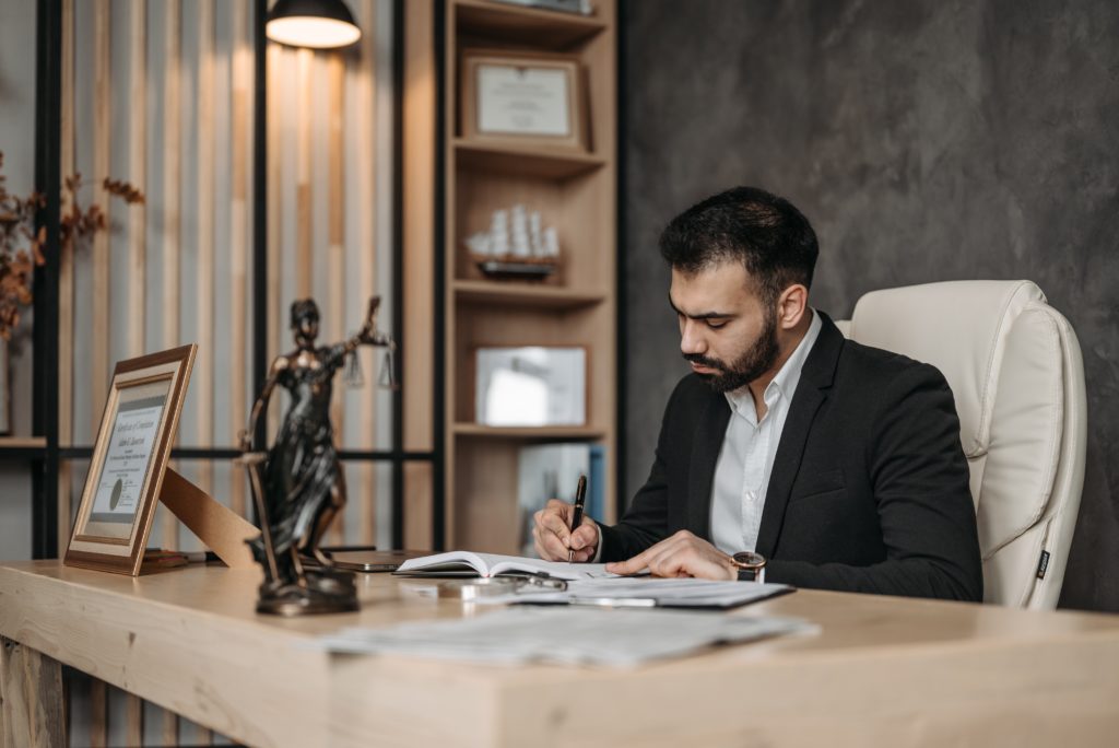 A lawyer signs papers for a case.